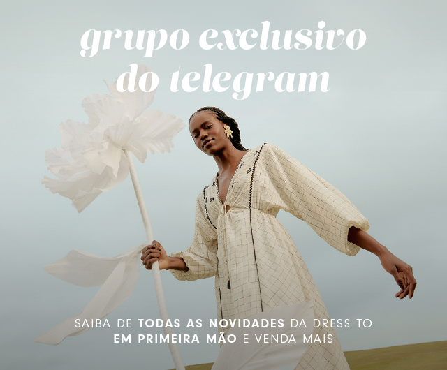 Modelo mulher usando vestido off-while  estampado com padronagem xadrez com decote em v, segurando uma flor em um dia de céu azul. Banner indica: Grupo exclusivo do Telegram. Saiba todas as novidades da Dress to e venda mais